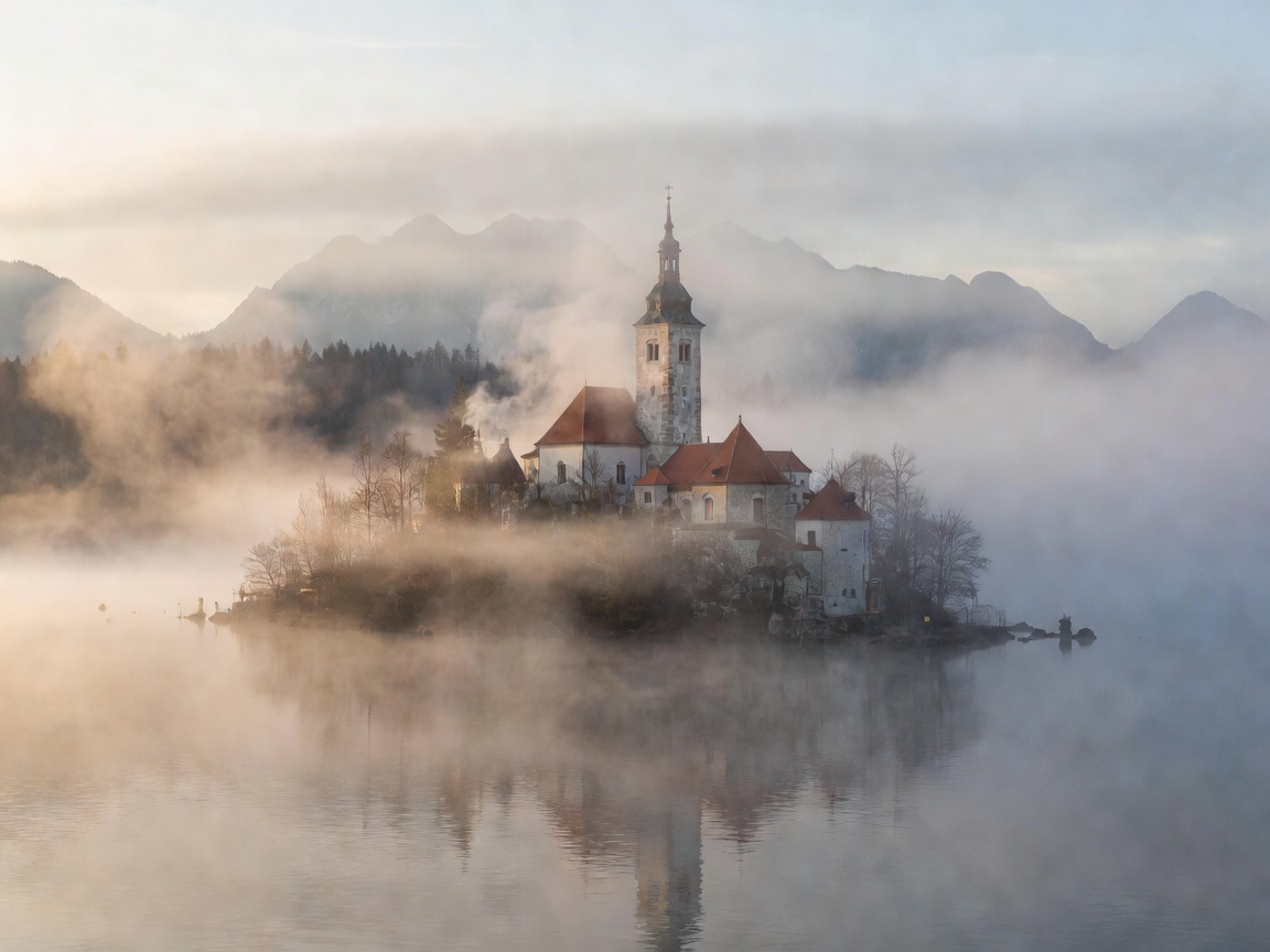 Lake Bled church on island enveloped in morning fog Slovenia