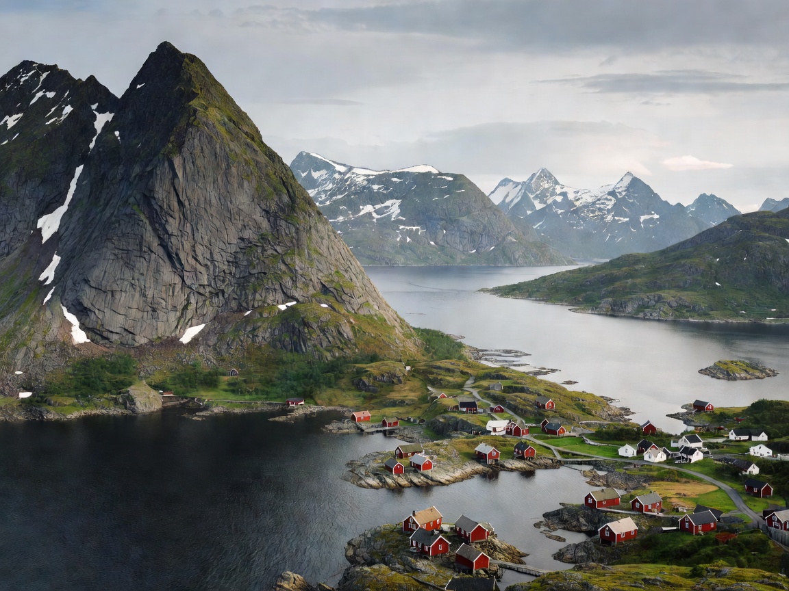 Red rorbuer fishing cabins on stilts in Reine Lofoten Islands Norway with snowy mountains